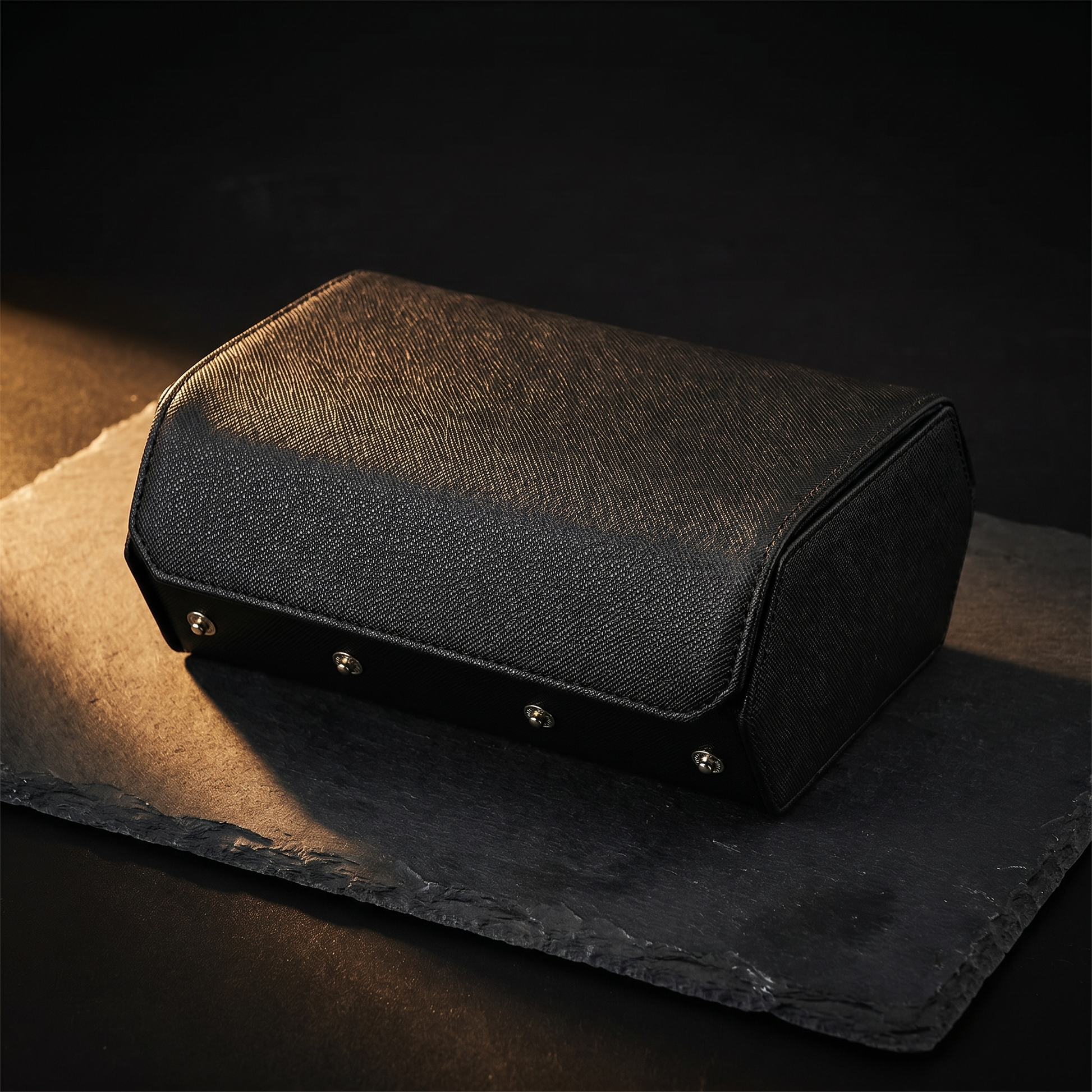 Black leather hexagonal watch roll closed, snap-stud closure, moody
